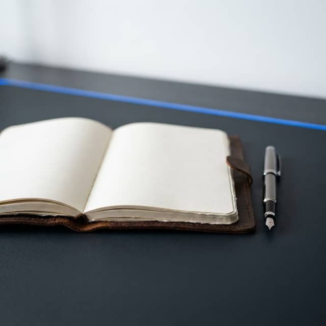 Professional notebook and pen on a dark desk