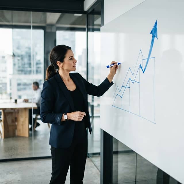 Marketing strategist mapping out compounding growth on a whiteboard