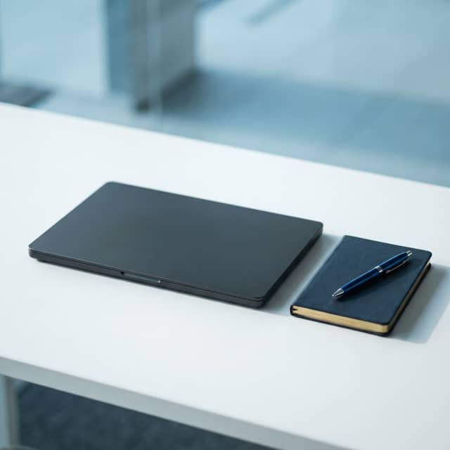 Minimalist professional workspace with laptop and notebook