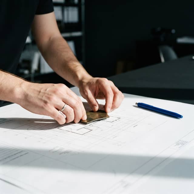 Professional hands placing material on a clean white surface