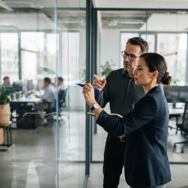 Marketing professionals planning on a glass wall
