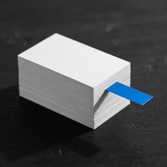 A stack of professional business cards with a single blue accent