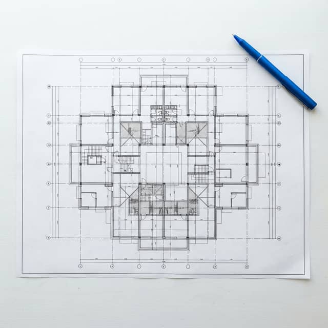 A blueprint of a complex grid on a white desk