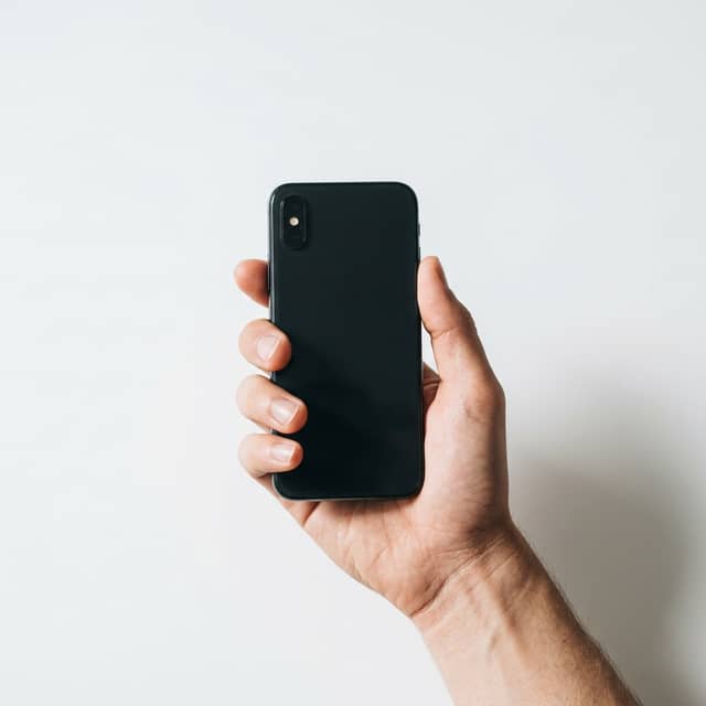 Hand holding phone with buyer-intent search query