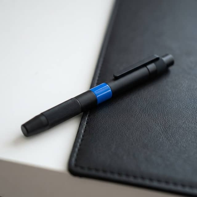 Close up of premium black pen with blue accent on desk