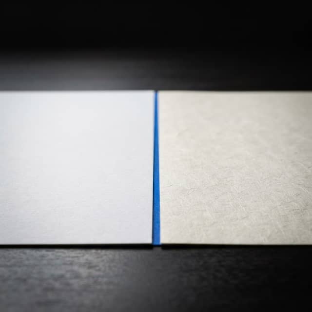 Comparison of two distinct paper textures on a desk separated by a single blue line
