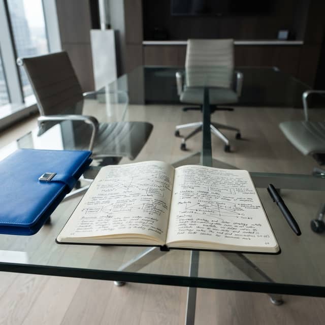 Professional notebook and pen on a boardroom table