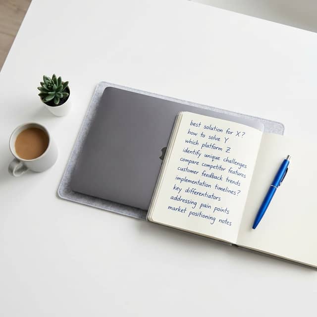 Laptop and research notebook with buyer questions listed