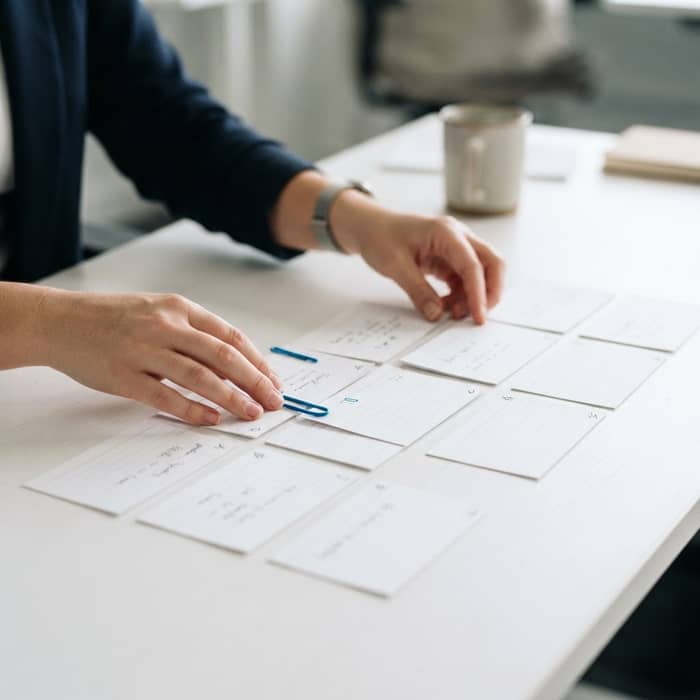 Professional hands organizing strategic index cards on a desk